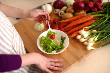 Genç kadın mutfakta yemek pişiriyor. Sağlıklı Yemek