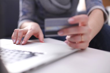Masa başında oturan kadın laptop ve kredi kartı ile alışveriş