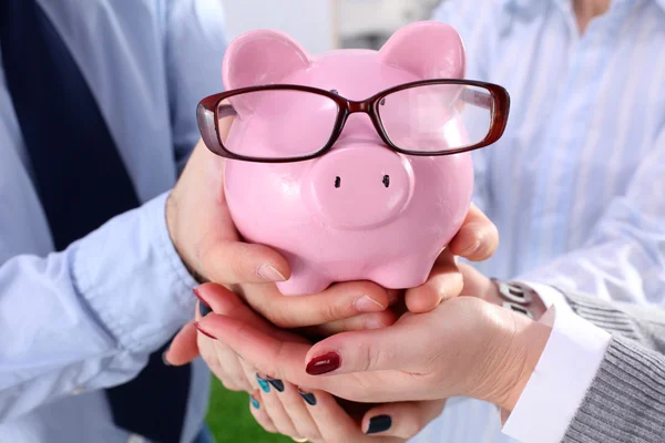 Zakenman houden piggy vak permanent in office — Stockfoto
