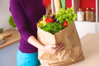 meyve ve sebze dolu alışveriş kese kağıdı tutan pozitif sağlıklı mutlu kadın