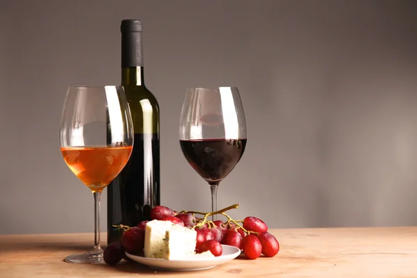 Botella de vino y copa de vino en una mesa de vidrio —  Fotos de Stock