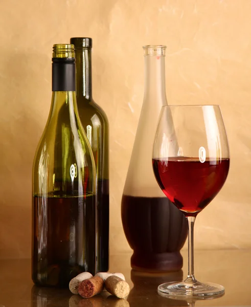 Bottiglia di vino e bicchiere di vino su un tavolo di vetro — Foto Stock