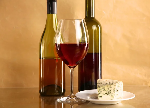 Şarap şişesi ve cam masa üzerinde şarap kadehi — Stok fotoğraf