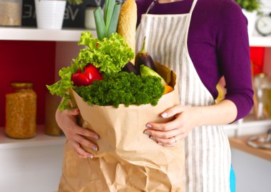 meyve ve sebze dolu alışveriş kese kağıdı tutan pozitif sağlıklı mutlu kadın