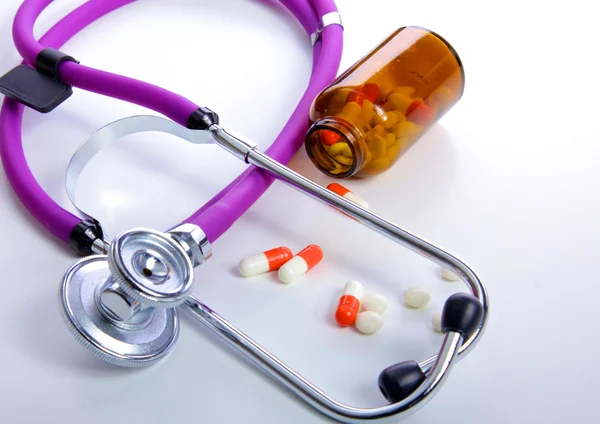 Tabletki, tabletki i stetoskop na białym tle — Zdjęcie stockowe