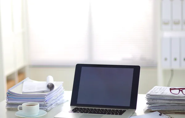 Laptop mit Ordnerstapel auf Tisch auf weißem Hintergrund — Stockfoto