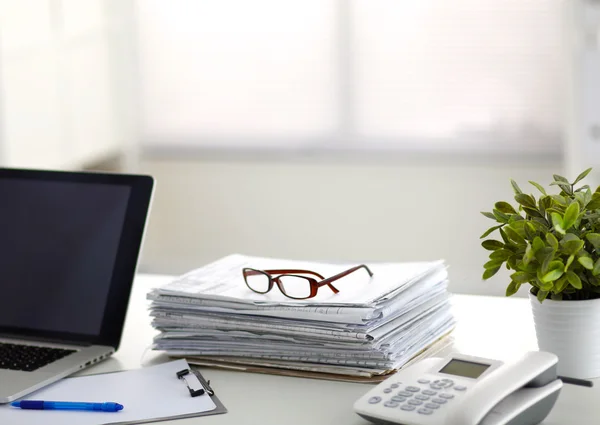 Laptop mit Ordnerstapel auf Tisch auf weißem Hintergrund — Stockfoto