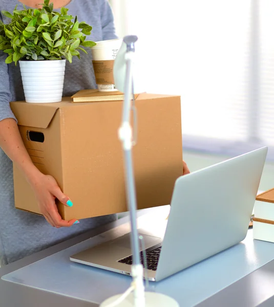 Happy team of businesspeople moving office, packing boxes, smiling