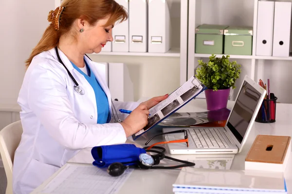 Doctora en el escritorio en el consultorio — Foto de Stock