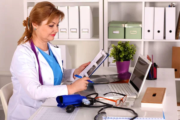 Doctora en el escritorio en el consultorio — Foto de Stock