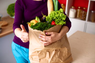 meyve ve sebze dolu alışveriş kese kağıdı tutan pozitif sağlıklı mutlu kadın