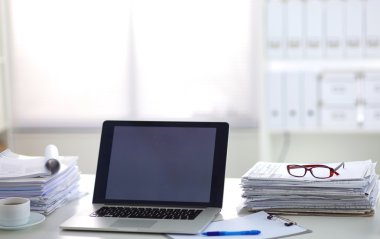 Beyaz arkaplanda dizin yığını olan dizüstü bilgisayar