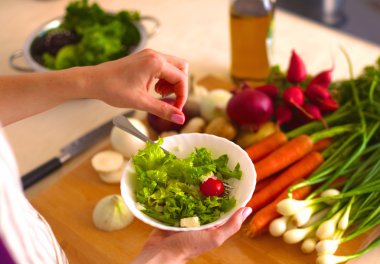 Genç kadın mutfakta yemek pişiriyor. Sağlıklı Yemek