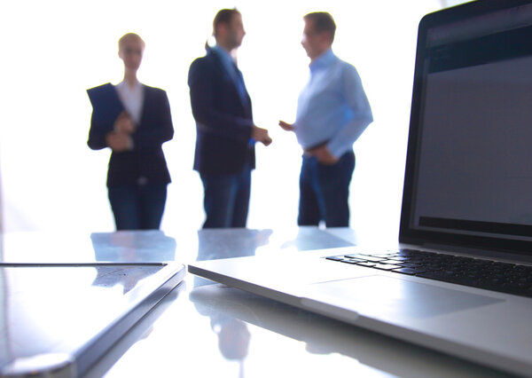 Сосредоточься на ноутбуке. Размытые люди на заднем плане
