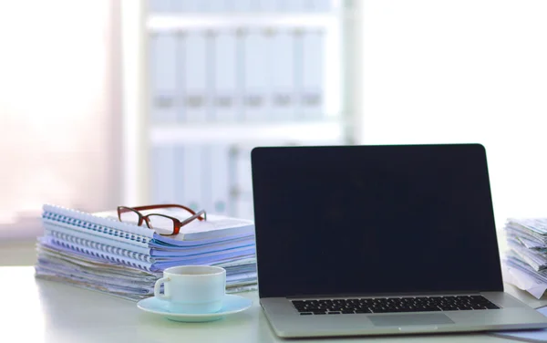 Laptop mit Ordnerstapel auf Tisch auf weißem Hintergrund — Stockfoto