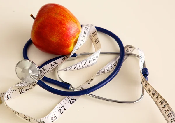 Estetoscopio con manzanas rojas sobre fondo blanco — Foto de Stock