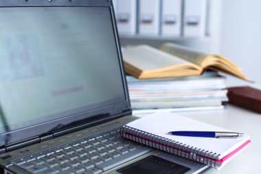 Beyaz arkaplanda dizin yığını olan dizüstü bilgisayar