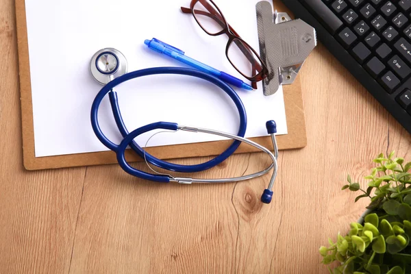 Lékařský fonendoskop u notebooku na dřevěný stůl — Stock fotografie