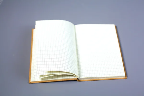 Notebook s hromadou složek na stole na bílém pozadí — Stock fotografie