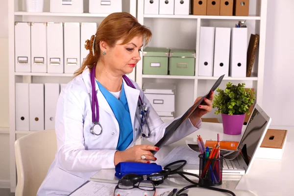 Doctora en el escritorio en el consultorio — Foto de Stock