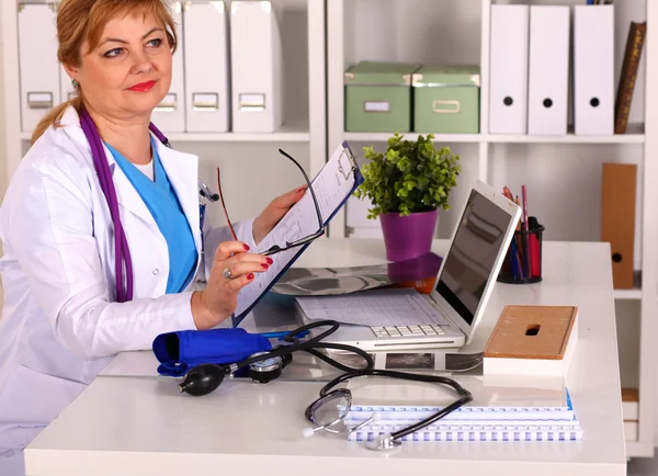 Doctora en el escritorio en el consultorio —  Fotos de Stock