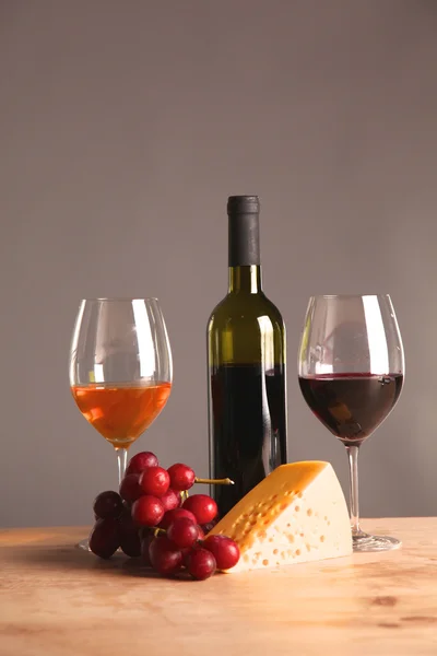 Botella de vino y copa de vino en una mesa de vidrio —  Fotos de Stock