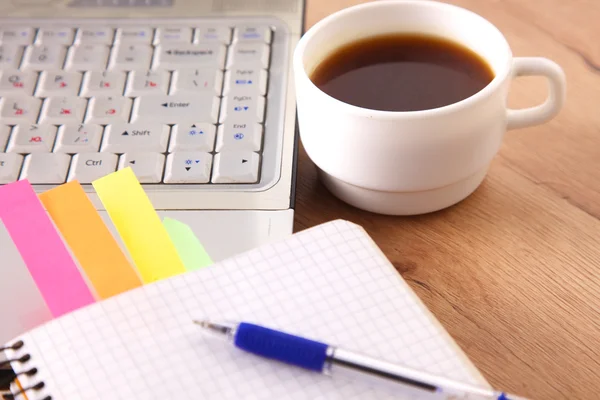 Mesa de escritório com bloco de notas em branco e laptop — Fotografia de Stock