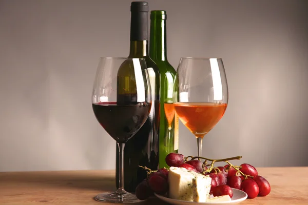 Botella de vino y copa de vino en una mesa de vidrio —  Fotos de Stock