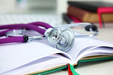 Bir dizüstü bilgisayar arka plan ve kitaplar yatan stetoskop