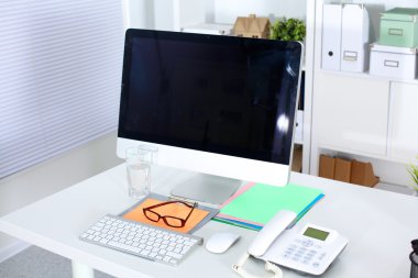 Bilgisayarı ve ahşap masasında akıllı telefonu olan bir ofis.