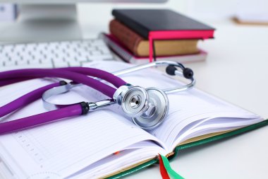 Bir dizüstü bilgisayar arka plan ve kitaplar yatan stetoskop