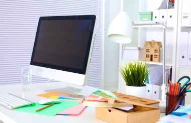 Bilgisayarı ve ahşap masasında akıllı telefonu olan bir ofis.