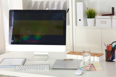 Bilgisayarı ve ahşap masasında akıllı telefonu olan bir ofis.