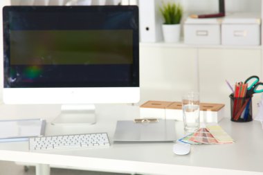 Bilgisayarı ve ahşap masasında akıllı telefonu olan bir ofis.