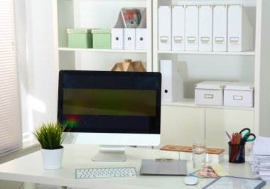 Bilgisayarı ve ahşap masasında akıllı telefonu olan bir ofis.
