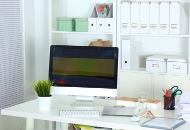 Bilgisayarı ve ahşap masasında akıllı telefonu olan bir ofis.