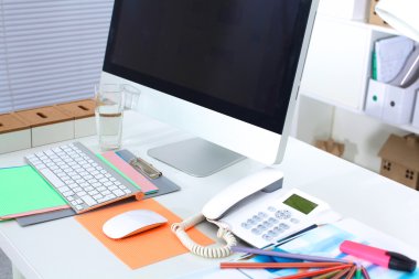 Bilgisayarı ve ahşap masasında akıllı telefonu olan bir ofis.