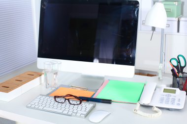 Bilgisayarı ve ahşap masasında akıllı telefonu olan bir ofis.