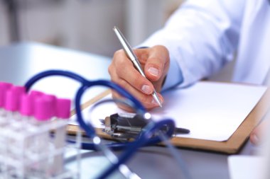 Doktor onun masasında arka planda tıbbi malzeme ile çalışma