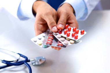 Doktorların elinde bir sürü farklı hap var.