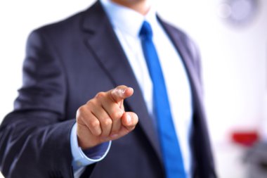 Genç işadamı ofiste dizüstü bilgisayarla çalışıyor.