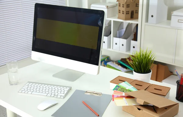 Bilgisayarı ve ahşap masasında akıllı telefonu olan bir ofis.