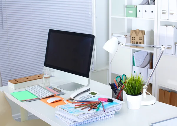 Bilgisayarı ve ahşap masasında akıllı telefonu olan bir ofis.