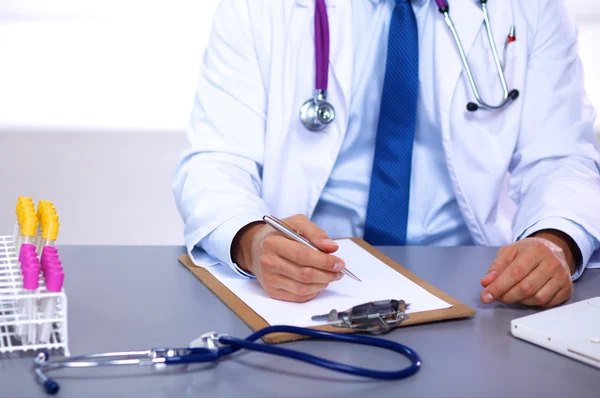 Médico em sua mesa de trabalho com equipamentos médicos em segundo plano — Fotografia de Stock