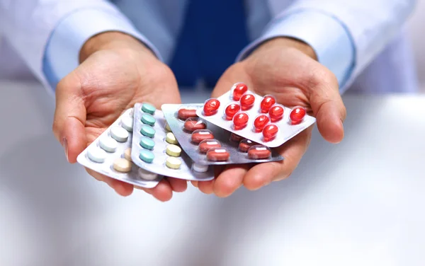 Рука лікарів, які тримають багато різних таблеток — стокове фото