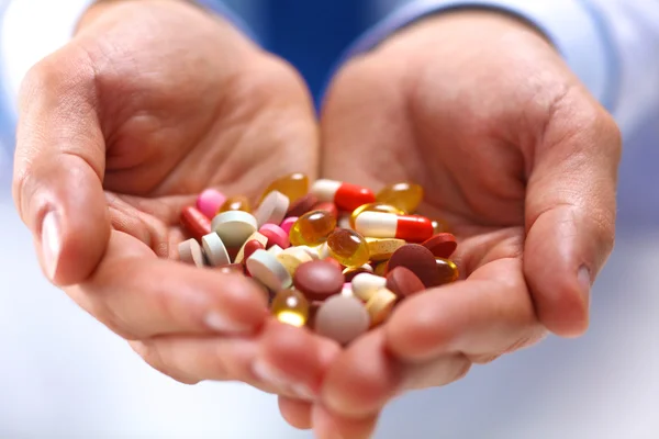 Hand of doctors holding many different pills — Stock Photo, Image