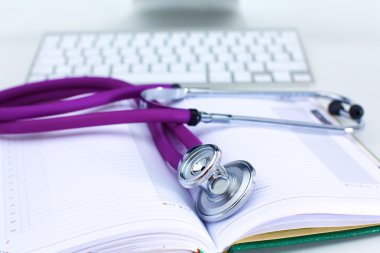 Açık bir kitap bir masada yatan stetoskop