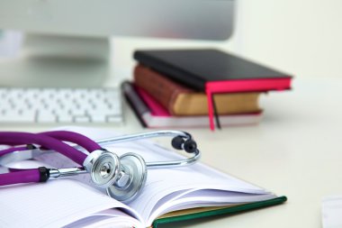 Açık bir kitap bir masada yatan stetoskop
