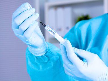 Doktor, elinde şırınga yakın çekim