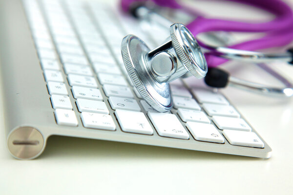 medical stethoscope lies on a computer keyboard